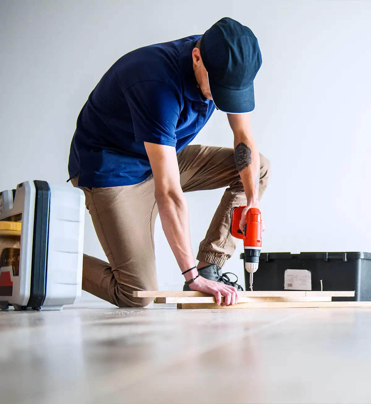 Handyman using a power drill for carpentry repair work on wood